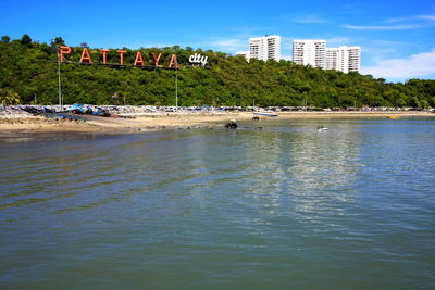 Scenic view of sea by buildings against sky