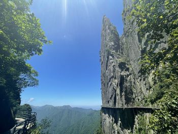 Panoramic view of rock formation amidst trees against sky