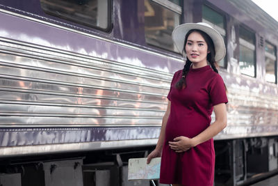 Portrait of young woman standing in train