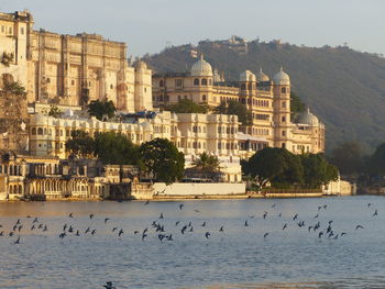Buildings by sea against sky