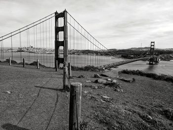 View of san francisco golden gate suspension bridge against cloudy sky in black and white