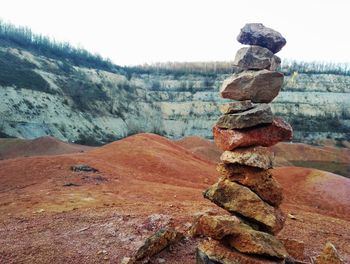 Close-up of rocks on each other against sky