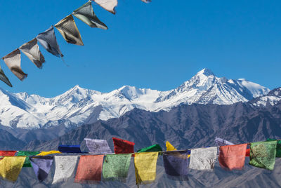 Low angle view of flags against mountains during winter