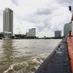 Buildings in city against cloudy sky