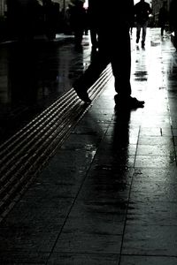 Low section of people walking on wet street