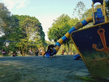 Boy on playground against sky