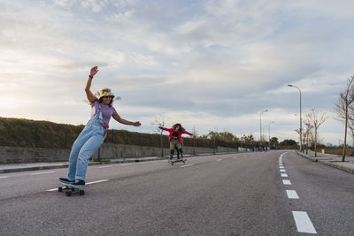 Female friends having fun while riding skates on road