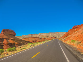 Road leading towards blue sky