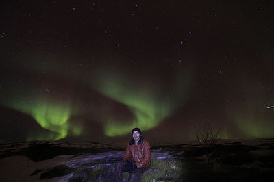 Man standing on mountain against sky at night