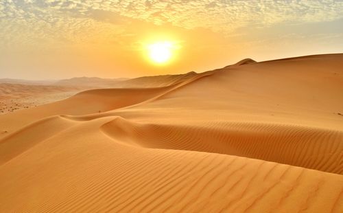 Scenic view of desert against sky during sunset