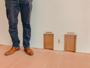Low section of man standing on floor at home