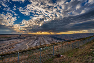 Scenic view of agricultural field against sky during sunset