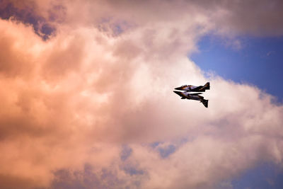 Low angle view of silhouette airplane against sky