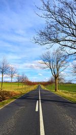 Road amidst trees against sky