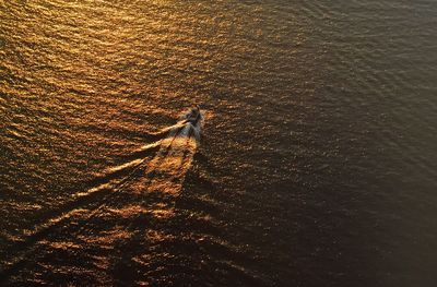 High angle view of boat moving in sea during sunset