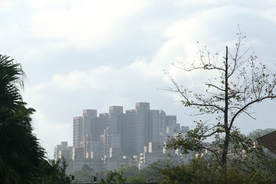 View of cityscape against cloudy sky