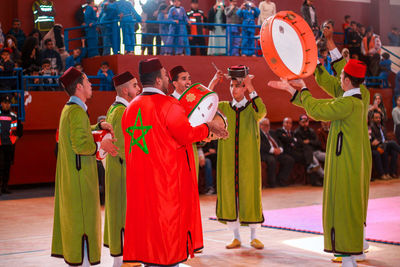 People wearing traditional clothing playing music 