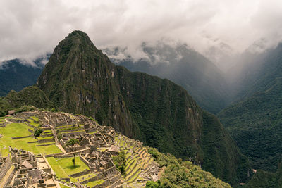 Scenic view of machu picchu and  mountains against cloudy sky