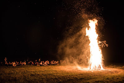 Bonfire on field with fire crackers at night