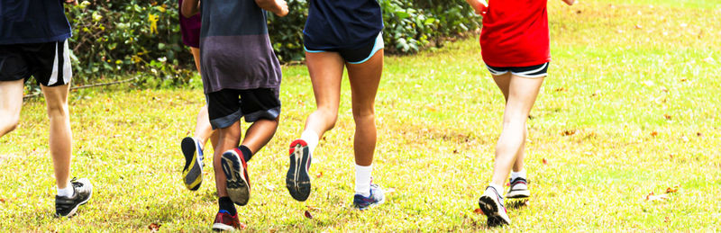 Low section of people running on soccer field