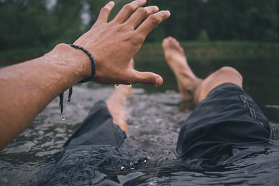 Low section of man swimming in lake