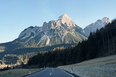 Road amidst mountains against clear sky