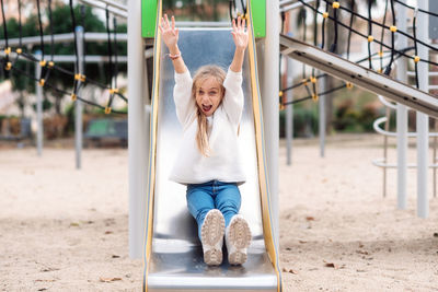 Portrait of girl sliding in playground