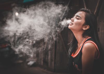 Portrait of young woman smoking cigarette