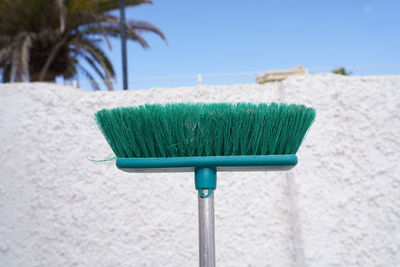 Close-up of plastic chairs on beach against blue sky