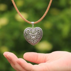 Cropped hand with heart shape pendant