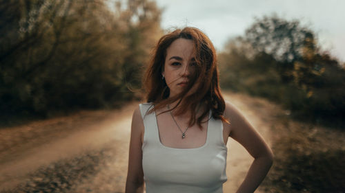 Portrait of young woman standing on field