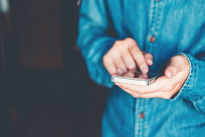 Midsection of man using mobile phone