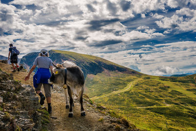 Panoramic view of people walking on mountain against sky