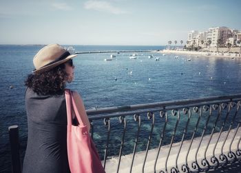 Woman leaning on railing while looking at view