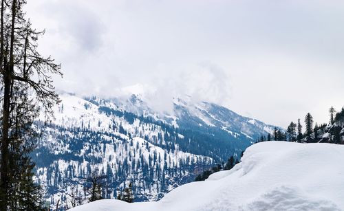 Scenic view of snow covered mountains against sky