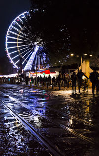 Illuminated ferris wheel in city at night