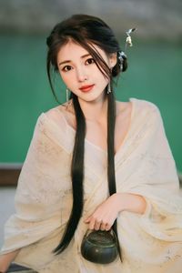Portrait of smiling young woman standing against sky