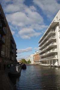 Buildings by swimming pool in city against sky