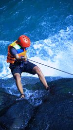 Rear view of man surfing in sea