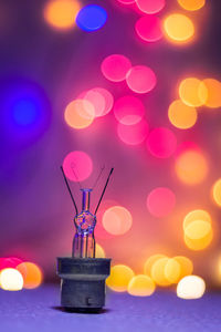 Close-up of illuminated light bulb against sky