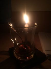 Close-up of illuminated tea light candles on table