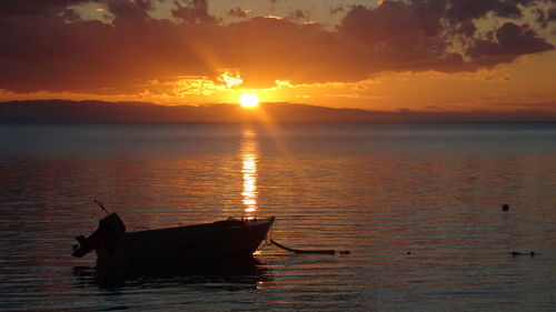 Silhouette boat in sea against sky during sunset