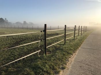 Fence on field against clear sky