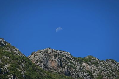 Low angle view of mountains against clear blue sky