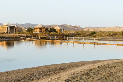 Houses by lake against clear sky