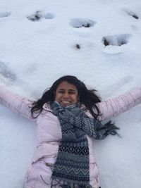 Portrait of smiling young woman standing in snow