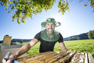 Portrait of man with honeycombs against clear sky