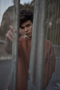 Portrait of man standing by gate