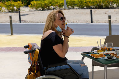 Young woman eating food on table