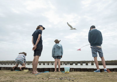 Friends catching crabs with fishing net during vacation